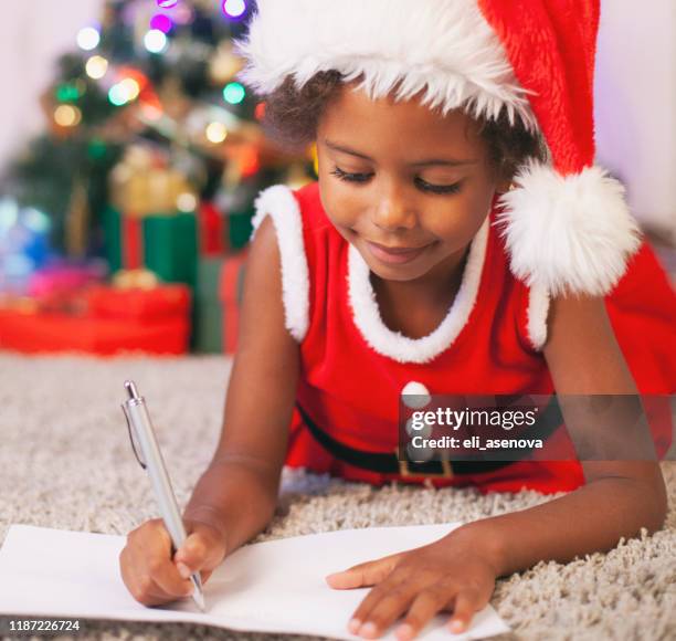 christmas african american child writing a letter to santa claus - santa claus lying stock pictures, royalty-free photos & images