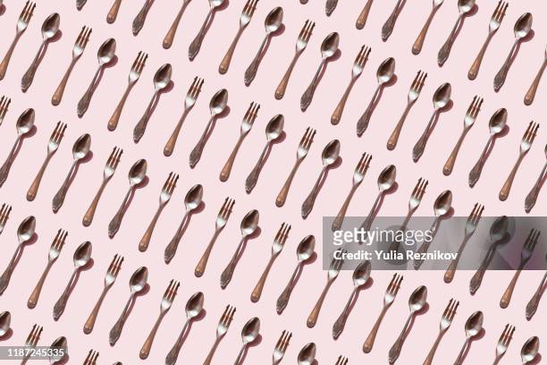 repeated spoon and fork on the pink background - colher talheres imagens e fotografias de stock