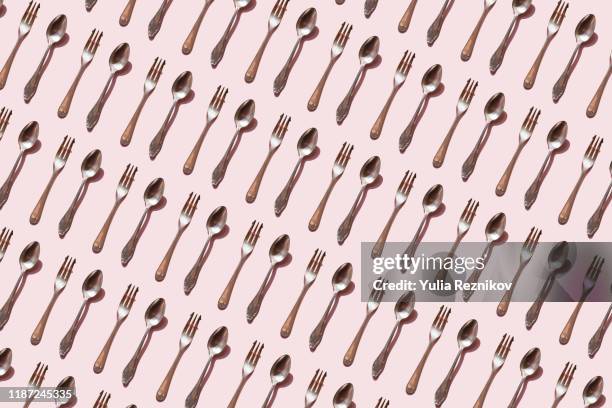 repeated spoon and fork on the pink background - ätutrustning bildbanksfoton och bilder