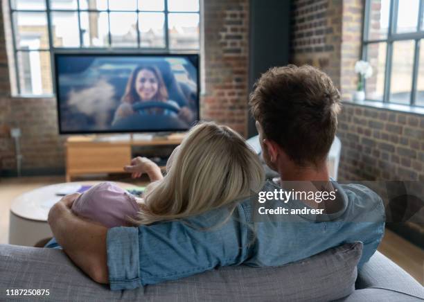 couples affectueux regardant la télévision à la maison - regarder tv photos et images de collection