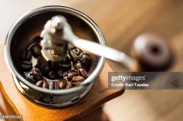 an old-fashioned coffee grinder with roasted coffee beans - coffee grinder stock-fotos und bilder