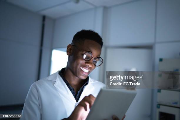 young scientist using digital tablet in laboratory - doctor reading stock pictures, royalty-free photos & images