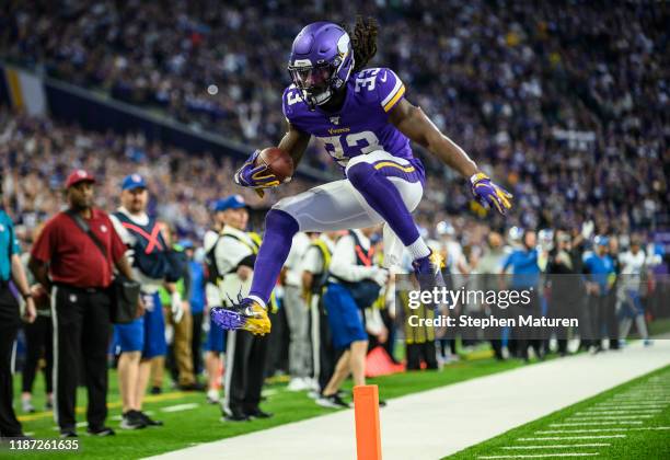 Dalvin Cook of the Minnesota Vikings runs with the ball and leaps over the goal line for a touchdown in the second quarter of the game against the...