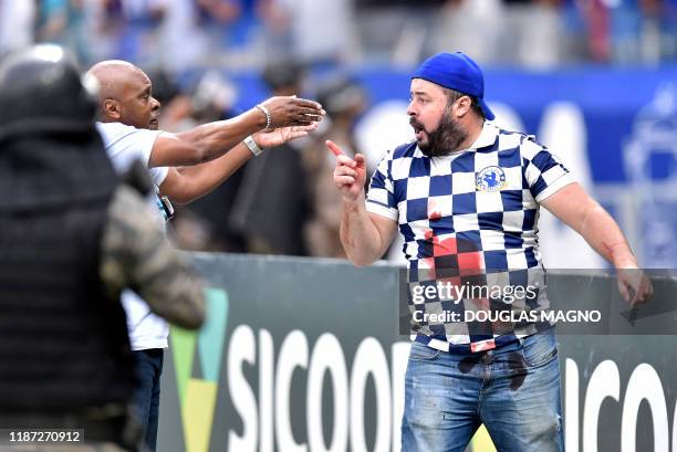 Fan of Brazil's Cruzeiro gestures stained with blood after clashes erupted during the Brazilian Championship football match against Palmeiras, in...