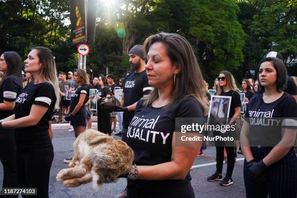 Animal rights activists from Animal Equality Brasil hold up pictures of animals mistreated and animal carcasses, during a demonstration to protest...