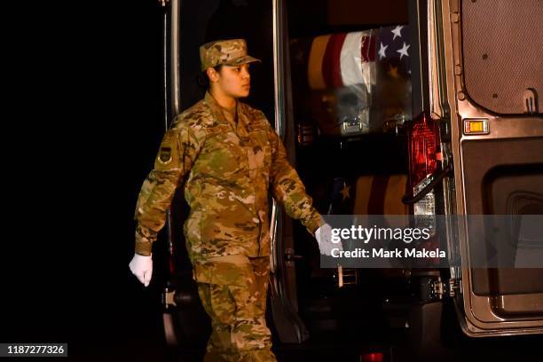 Door attendant Staff Sgt. Siannie L. Concepcion prepares to close the van door transporting three transfer cases for fallen U.S. Navy service...