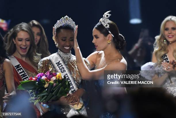 Miss Universe 2018 Philippines' Catriona Gray crowns the new Miss Universe 2019 South Africa's Zozibini Tunzi on stage during the 2019 Miss Universe...