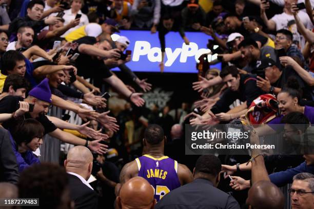 LeBron James of the Los Angeles Lakers walks off the court past fans following the NBA game against the Phoenix Suns at Talking Stick Resort Arena on...