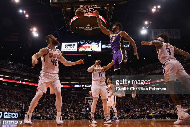 JaVale McGee of the Los Angeles Lakers slam dunks the ball over Aron Baynes of the Phoenix Suns during the second half of the NBA game at Talking...