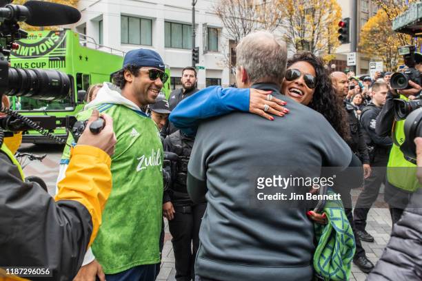 Seattle Sounders head coach Brian Schmetzer hugs co-owner and singer Ciara alongside her husband co-owner and Seattle Seahawks quarterback Russell...