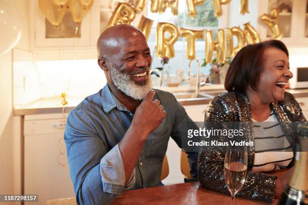 man and woman enjoying birthday party at home - 55 to 60 years old african american male stock pictures, royalty-free photos & images
