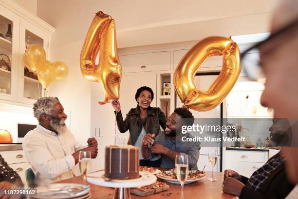 woman with number 40 balloons at birthday party - 40 birthday foto e immagini stock