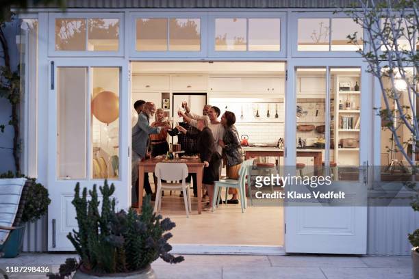 cheerful family toasting drinks during birthday party - residential building stock-fotos und bilder