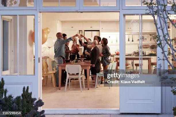 family toasting drinks during birthday party - esstisch stock-fotos und bilder