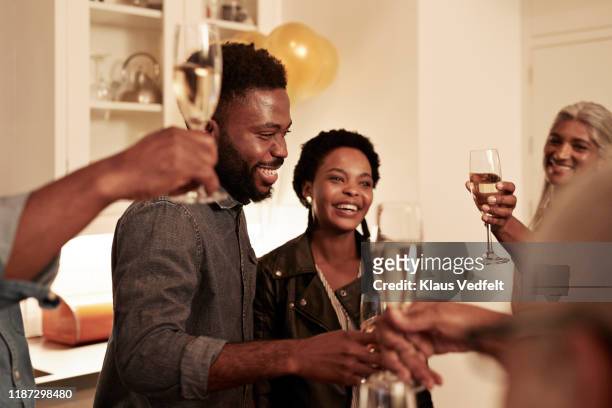 smiling family enjoying drinks at birthday party - feiern jubiläum stock-fotos und bilder