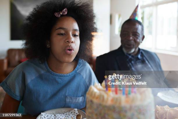 girl blowing candles during birthday party - family teenager home life stock pictures, royalty-free photos & images