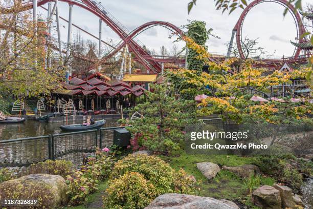 oriental gardens with amusement rides in the background - tivoli copenhagen stock pictures, royalty-free photos & images