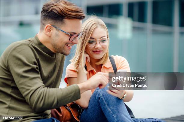 jong paar studenten zittend op een bankje - male student wearing glasses with friends stockfoto's en -beelden