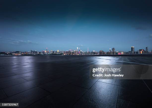 empty parking lot with cityscape background - urban square city night stock pictures, royalty-free photos & images