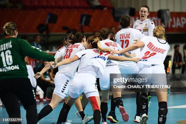 Serbia's players celebrate their win during the main round group 1 match between Germany and Serbia at the Women's Handball World Championship in...