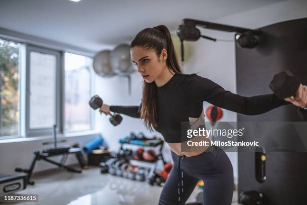 健身年輕女子舉重在健身房 - dumbbell 個照片及圖片檔