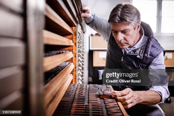 typesetter working in an old-fashioned printing plant - typesetter stock pictures, royalty-free photos & images