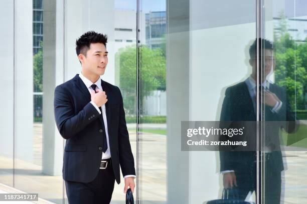 one asian men walking in bright aisle - one mid adult man only stock pictures, royalty-free photos & images