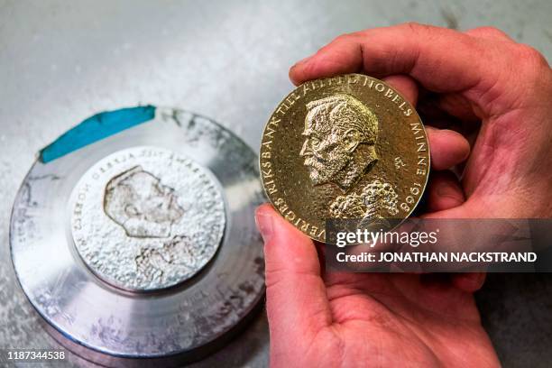 Niklas Qvarnstrom, a craftsman in charge of the Nobel Prize medals, works during the production of the medals on October 29, 2019 in Eskilstuna,...