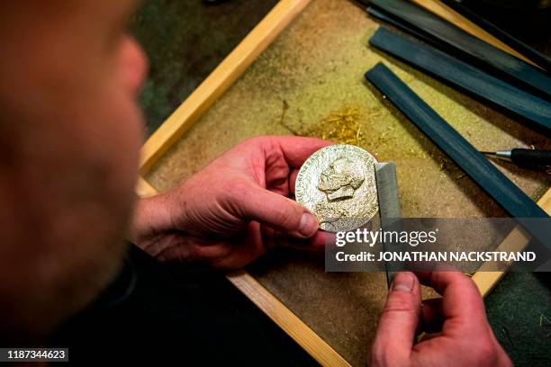 Niklas Qvarnstrom, a craftsman in charge of the Nobel Prize medals, works during the production of the medals on October 29, 2019 in Eskilstuna,...