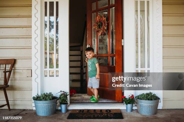 young boy closing front door in summer - front door open stock pictures, royalty-free photos & images