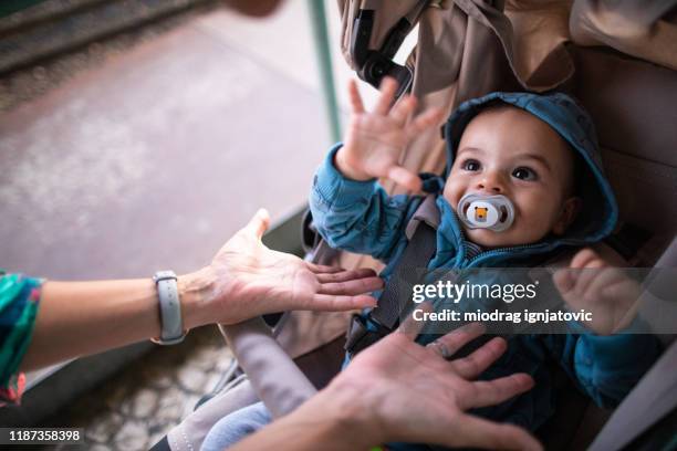 baby in wandelwagen die met moeder op de straat speelt - carriage stockfoto's en -beelden