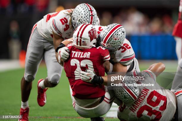 Ohio State Buckeyes cornerback Shaun Wade and Ohio State Buckeyes linebacker Tuf Borland tackle Wisconsin Badgers running back Jonathan Taylor during...