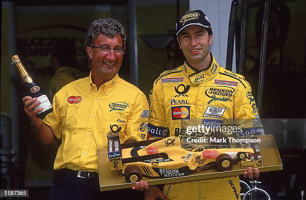 Heinz-Harald Frentzen of Germany celebrates signing a new two year contract with Jordan Mugen-Honda team boss Eddie Jordan during the German Formula...