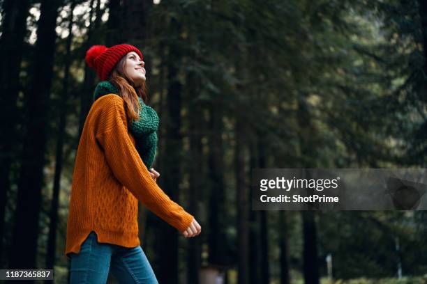 woman smiles and walks in the forest looking at nature, beautiful forest - fashion orange colour stock pictures, royalty-free photos & images