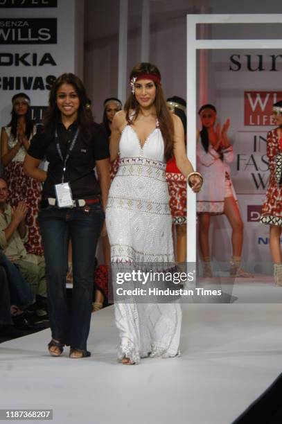 Fashion designer Surily Goel walks the ramp with model Priya Chatwal during her show at the Wills Lifestyle India Fashion Week at Pragati Maidan, on...