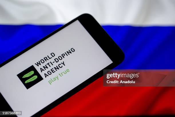 Russian flag is seen behind as World Anti-Doping Agency logo is displayed on a smart phone screenin this illustration photo in Ankara, Turkey on...