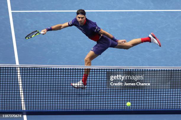 Robert Farah, playing partner of Juan Sebastian Cabal of Colombia stretches to play a forehand in their doubles match against Jean-Julien Rojer of...