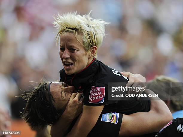 S striker Abby Wambach celebrates with her teammate USA's midfielder Megan Rapinoe after scoring the 2-2 during the quarter-final match of the FIFA...