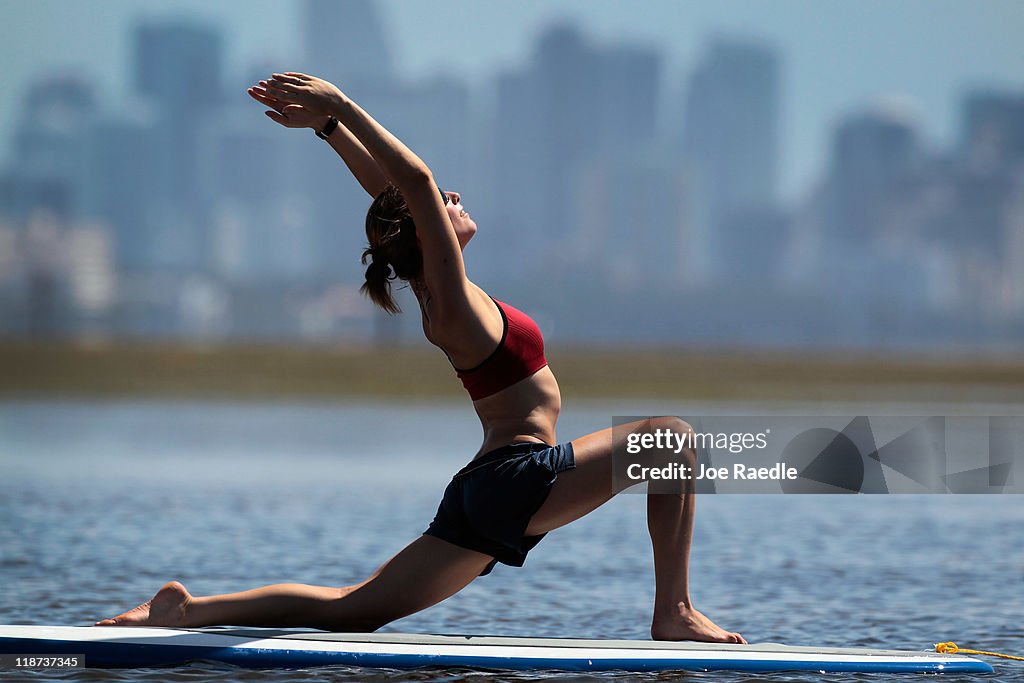 Practioners Enjoy Serenity Of Paddleboard Yoga