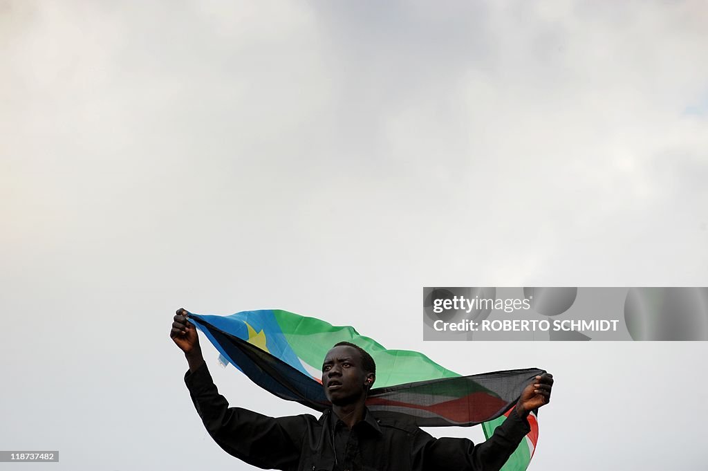 A South Sudanese spectator waves his cou
