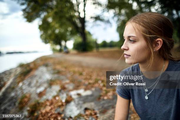 portrait of a young woman at the riverside contemplating - one young woman only stock pictures, royalty-free photos & images