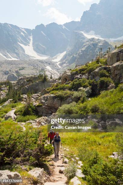 hikers on trail with mountain views in rocky mountain national park - rocky mountain national park stock pictures, royalty-free photos & images