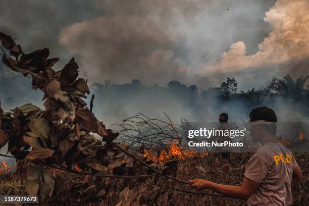 Indonesian police officers try to extinguish forest fire at Rumbai Pesisir village Pekanbaru, Riau, Indonesia, on October 4, 2019. During Indonesia's...