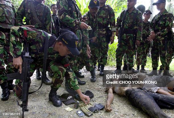 Indonesian troops check the bodies of suspected Freedom Aceh Movement rebels after they were shot in Lhokseumawe, Aceh province, 25 May 2003. A...