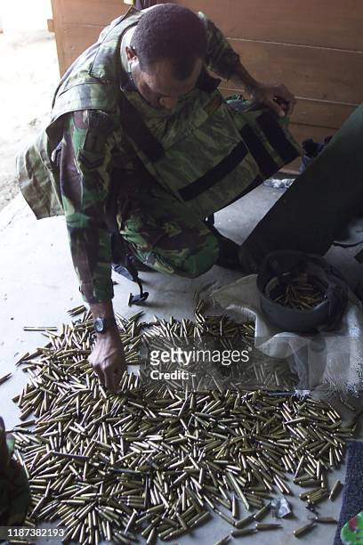 Indonesian soldier picks up bullets at a army camp before the battle with GAM , at Peurlak, east Aceh 23 May 2003. Indonesian troops killed three GAM...