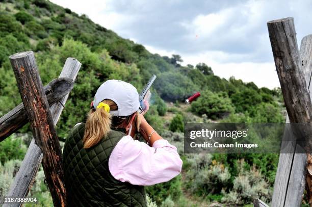 cathy beck shoots sporting clays while visiting colorado - tontaubenschießen stock-fotos und bilder