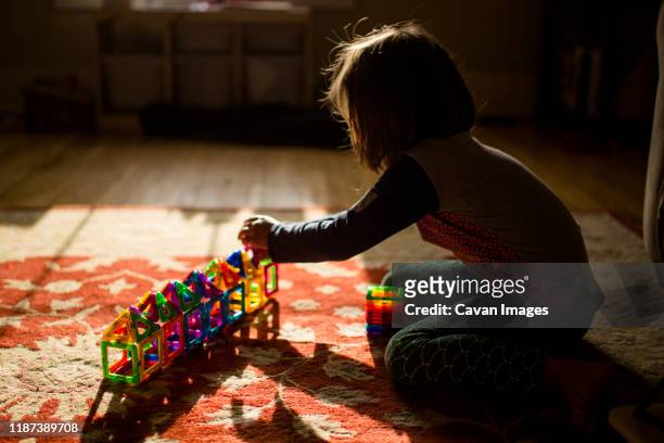 a child sits on the floor in golden morning light building with tiles - bridge built structure stock pictures, royalty-free photos & images