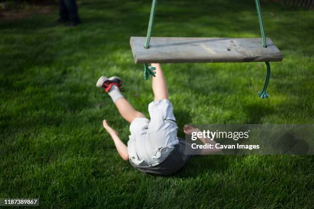 a child lays on the ground after falling from a wooden swing - bad condition stock pictures, royalty-free photos & images