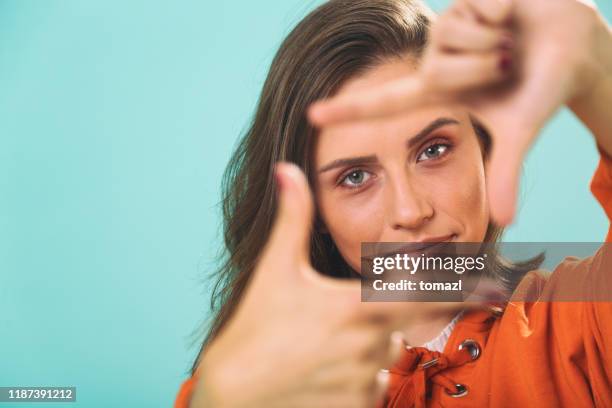 mulher nova que faz a composição do frame do dedo - dedos fazendo moldura - fotografias e filmes do acervo