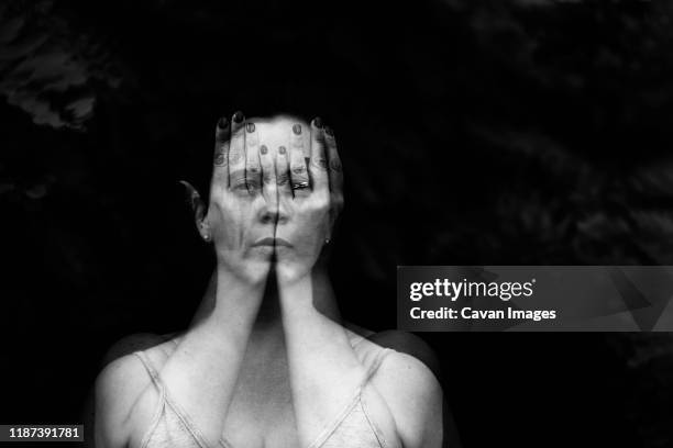 double exposure portrait of a female behind hands - double exposure face stock-fotos und bilder